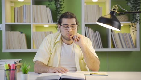 Thoughtful-male-college-student-studying,-doing-research.